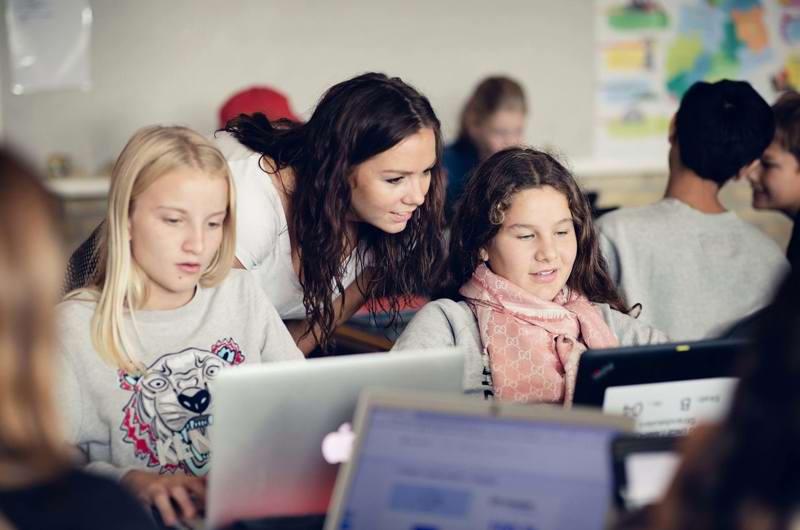 Børn og lærer med computer på Strandskolen